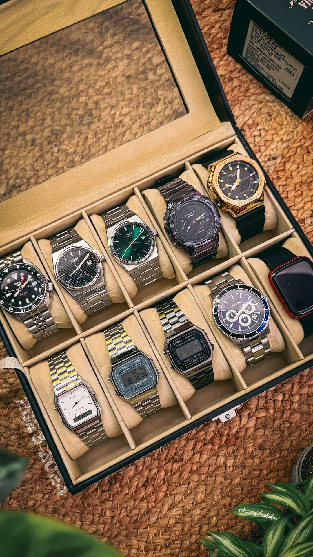 Hands presenting a velvet tray with several luxury watches during a private viewing