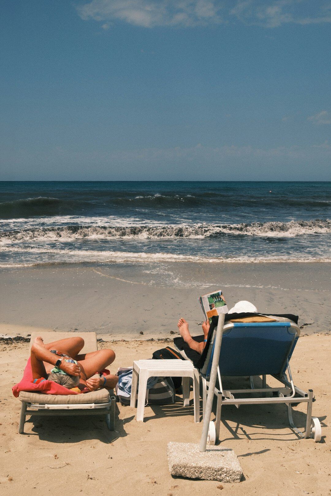 Luxury polarized sunglasses resting on a beach towel with the Atlantic coast in the background