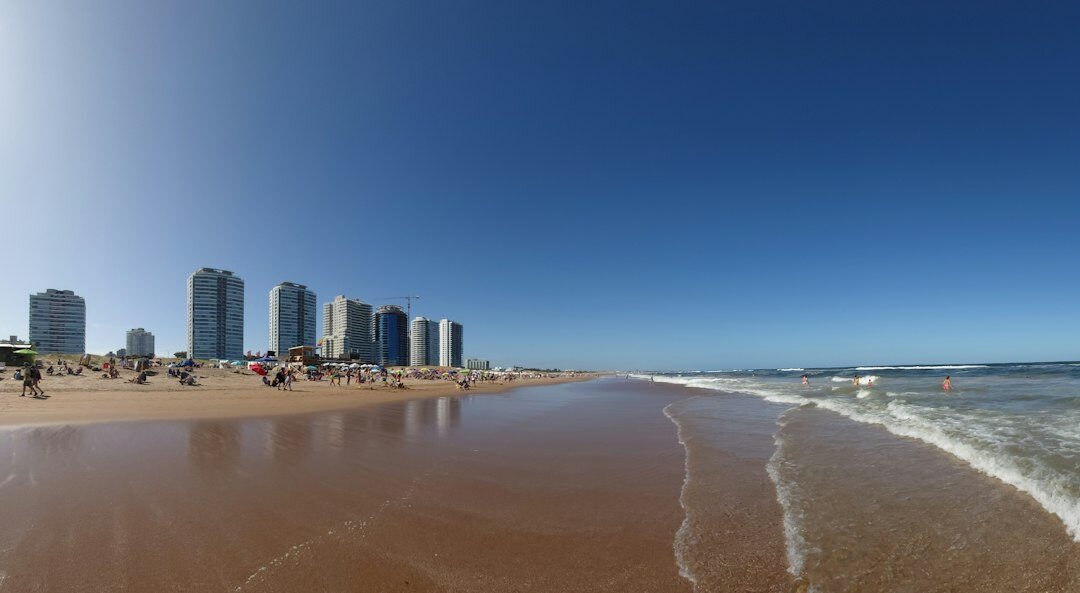 Golden hour sunrise over Punta del Este beach with the La Mano sculpture in the distance