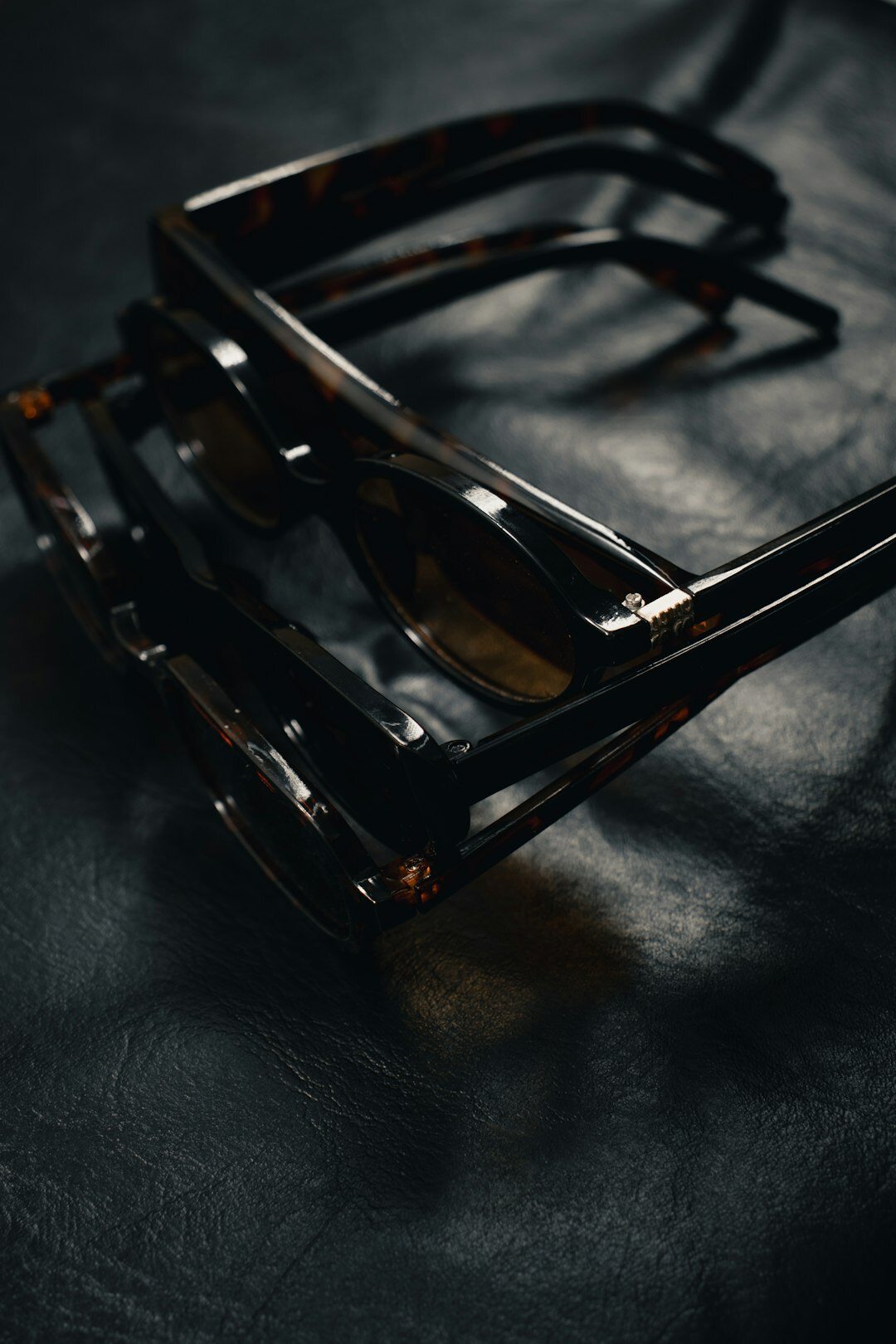 Hand-carved tortoiseshell acetate eyewear frames on dark velvet
